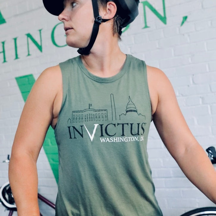 Woman wearing muscle tank top wearing a helmet and riding a bike 
